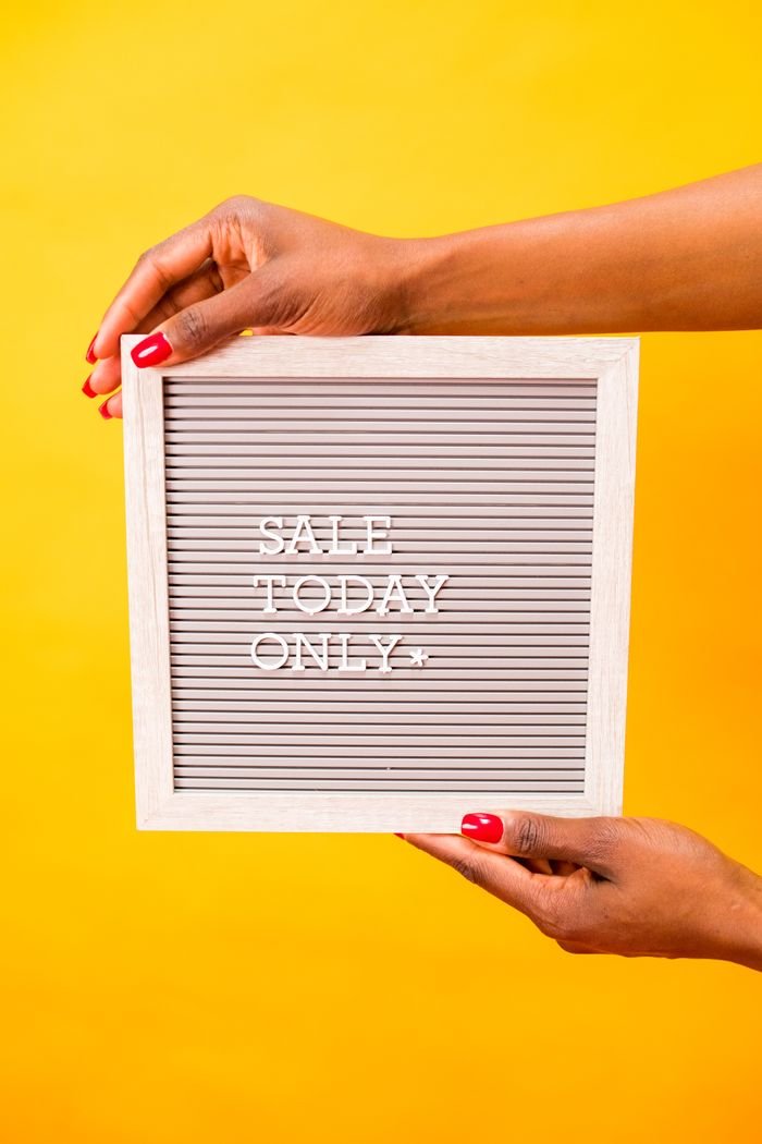 Square letter board with 'SALE TODAY ONLY' held by hands against a vibrant yellow background.